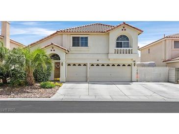 Charming two-story home with a tile roof, arched doorway, and a well-manicured front yard at 603 Fiddlehead Ave, Las Vegas, NV 89183