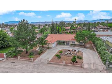 Stunning single-story home with a circular driveway, well-manicured landscaping, and mature trees at 3065 S Torrey Pines Dr, Las Vegas, NV 89146