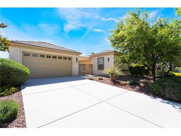 Inviting single-story home with attached two car garage, neutral color palette, and well manicured landscaping at 8236 Imperial Lakes St, Las Vegas, NV 89131