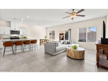 Bright open-concept living room featuring modern kitchen, breakfast bar, and comfortable seating area at 1783 Matteo Cove Pl, North Las Vegas, NV 89084