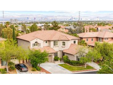 Two-story home boasts a red tile roof, manicured landscaping, and a view of the Las Vegas skyline at 366 Rancho La Costa St, Las Vegas, NV 89138