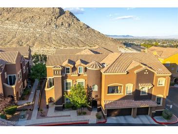 Stylish townhome featuring a 2-car garage, turret, desert landscaping, and mountain views at 3975 N Hualapai Way # 212, Las Vegas, NV 89129