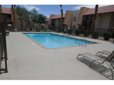 Community pool view surrounded by mature landscaping at condo complex in Nevada at 5220 Indian River Dr # 277, Las Vegas, NV 89103