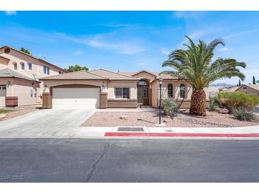 Charming single-story home with desert landscaping, a palm tree, and attached two-car garage at 5600 Blue Peak Ave, Las Vegas, NV 89131