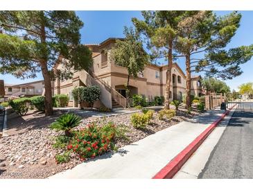 Condominium exterior featuring desert landscaping, mature trees, and walkway access at 5751 E Hacienda Ave # 105, Las Vegas, NV 89122
