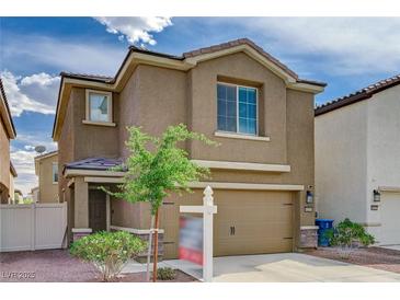 Two-story home featuring a two-car garage, neutral stucco, and a well-maintained front yard at 6231 Portland Treaty Ave, Las Vegas, NV 89122