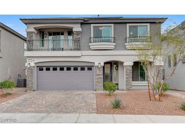 Two-story home with a two-car garage, balcony, stone accents, and well-maintained landscaping at 6618 Tangled Vines Ave, Las Vegas, NV 89139