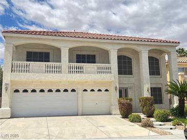 Stunning two-story home featuring a balcony, arched windows, and a three-car garage at 7851 Tidal Pool Ct, Las Vegas, NV 89139