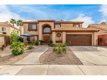 Charming two-story home featuring a tile roof, front yard landscaping and an attached two car garage at 905 Possum Hill St, Henderson, NV 89014