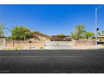 Charming single-story home with gated entrance and mature landscaping at 997 N Christy Ln, Las Vegas, NV 89110