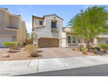 Charming stucco home with a two-car garage and beautifully designed desert landscaping at 1105 Strada Pecei, Henderson, NV 89011