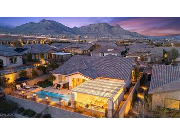 Stunning single-story home with a backyard pool and covered patio against a backdrop of picturesque mountains at 12217 Tempestad Ave, Las Vegas, NV 89138