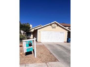 Inviting single-story home with a two-car garage and mature landscaping at 1676 Divinity St, Las Vegas, NV 89142