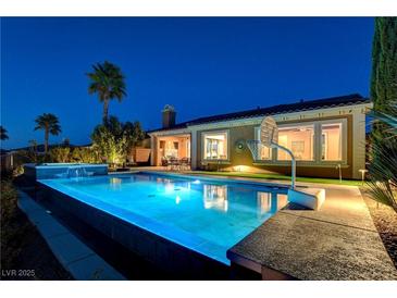 Inviting backyard pool and spa, with lush landscaping and outdoor seating, perfect for relaxation at 19 Contrada Fiore Dr, Henderson, NV 89011