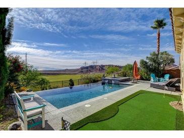 Stunning infinity pool with putting green and mountain views create an ideal outdoor oasis at 19 Contrada Fiore Dr, Henderson, NV 89011