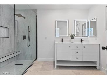 Modern bathroom featuring a double sink vanity and glass enclosed shower with marble tile at 5516 Ness Ave, Las Vegas, NV 89118