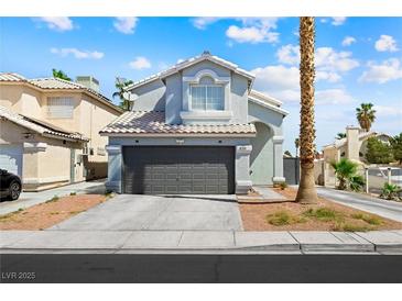 Charming two-story home featuring a gray garage door, a well-manicured lawn and blue sky background at 5950 Pacific Shores Dr, Las Vegas, NV 89142