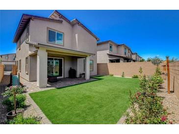 View of the well-kept backyard featuring a green lawn and a covered patio at 8898 Sasquatch Run Ave, Las Vegas, NV 89166