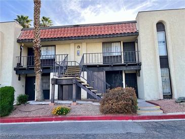 Two-story condo featuring a red tile roof and a well-maintained stucco exterior with black metal railings at 1440 Vegas Valley Dr # 2, Las Vegas, NV 89169