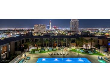Night view of a luxury condominium rooftop pool and lounge area, with the city skyline in the background at 353 E Bonneville Ave # 1302, Las Vegas, NV 89101