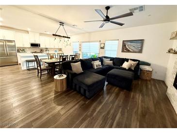 Open-concept living room with modern finishes and wood-style flooring, next to the kitchen at 600 N Carriage Hill Dr # 1082, Las Vegas, NV 89138