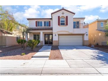 Two-story home with white exterior, balcony, double front door, and well-kept landscaping at 7098 Seabirds Pl, North Las Vegas, NV 89084
