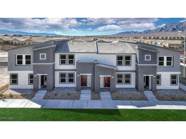 Modern townhome exteriors showcasing a gray and white color scheme and neat landscaping at 7384 Hayes Harbor Ct # Lot 213, North Las Vegas, NV 89084