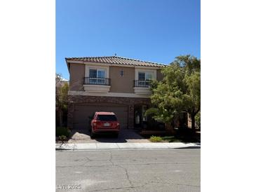 Charming two-story home with a two-car garage and brick accents, complemented by a well-manicured lawn and mature trees at 9823 Belle Marie Ct, Las Vegas, NV 89141