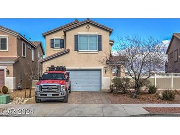 Charming two-story home featuring a neatly paved driveway, a well-maintained lawn, and an attached two-car garage at 1168 Aspen Cliff Dr, Henderson, NV 89011