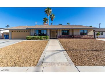 Charming single story home featuring well-maintained landscaping, and attractive desert rock at 1727 Cherokee Ln, Las Vegas, NV 89169