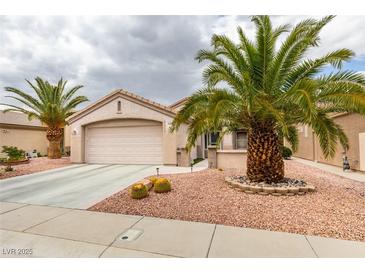 Charming single-story home featuring desert landscaping, complemented by mature palm trees and a two-car garage at 2164 Eagle Sticks Dr, Henderson, NV 89012