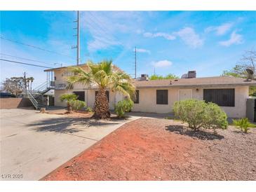 A charming multi-Gathering home with a desert landscape and mature palm tree in the front yard at 5112 Pebble Beach Blvd, Las Vegas, NV 89108
