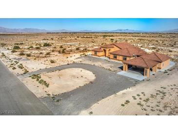 Expansive desert property featuring a sprawling home with a terracotta roof and a circular driveway at 5700 E Carter Ln, Pahrump, NV 89061