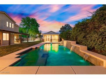 Beautiful backyard pool with waterfall features and ambient lighting, perfect for relaxation at 6335 Iginlas Goal Ave, Las Vegas, NV 89131