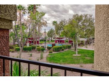 View of the community pool featuring a lush green landscape, mature trees and shaded seating areas at 7885 W Flamingo Rd # 2005, Las Vegas, NV 89147