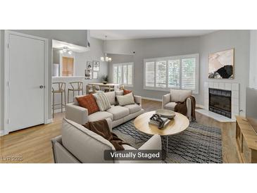 Bright living room features modern furniture, plantation shutters and a cozy fireplace at 8450 Alta Dr # 220, Las Vegas, NV 89145