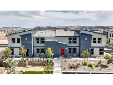 New two-story townhome with blue and gray accents, a red door, and desert landscaping at 4839 Orchid Ridge Ave # 96, Las Vegas, NV 89141