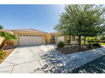 Charming single-story home featuring a two-car garage, mature landscaping, and well-maintained front yard at 7349 Royal Melbourne Dr, Las Vegas, NV 89131