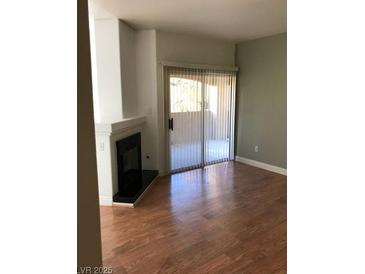 Bright living room with fireplace and sliding glass doors to balcony, and laminate wood floors at 9000 Las Vegas Blvd # 2097, Las Vegas, NV 89123