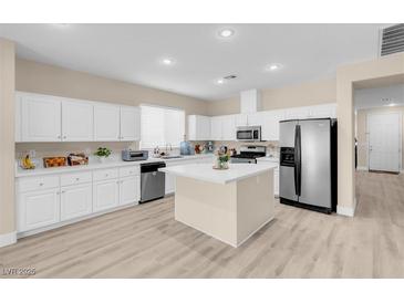 Bright kitchen features white cabinets, stainless appliances, and a center island at 11074 Caramel Crest Ct, Las Vegas, NV 89135