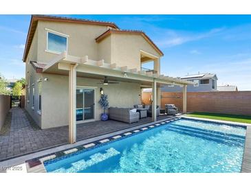 Inviting backyard oasis featuring a refreshing pool, covered patio, and comfortable outdoor seating area at 3136 Mossfield Ave, Henderson, NV 89052