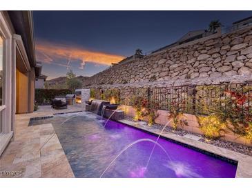 Inviting pool featuring a water feature and elegant landscaping at sunset at 33 Desert Juniper Ln, Henderson, NV 89011
