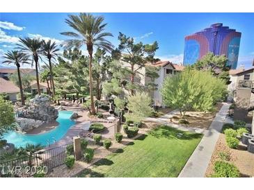 A luxurious community pool with waterfall feature, lounge chairs, and tropical landscaping at 4200 S Valley View Blvd # 3078, Las Vegas, NV 89103