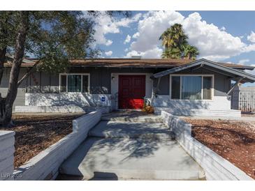 Charming single-story home features a red front door, gray exterior paint, and landscaped yard at 4509 Paseo Del Ray Dr, Las Vegas, NV 89121