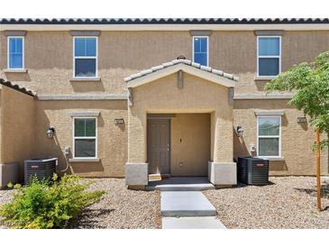 Inviting townhouse exterior with a covered porch, well-maintained landscaping, and neutral color scheme at 4612 Townwall St, Las Vegas, NV 89115