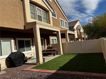 View of the backyard with a patio, barbeque, and artificial turf at 9133 Forest Willow Ave # 102, Las Vegas, NV 89149