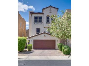 Charming stucco home featuring a two-car garage, manicured bushes, and well-maintained landscaping at 345 Gracious Way, Henderson, NV 89011