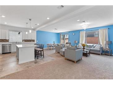 Bright, open-concept living space featuring modern furnishings, an adjacent dining area, and a stylish kitchen with bar seating at 5937 W Frias Ave, Las Vegas, NV 89141
