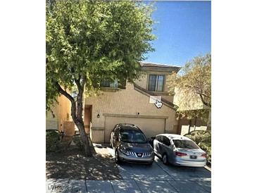 Inviting home featuring a two-car garage, mature shade tree, and neutral stucco exterior at 6531 Goldfield St, North Las Vegas, NV 89084
