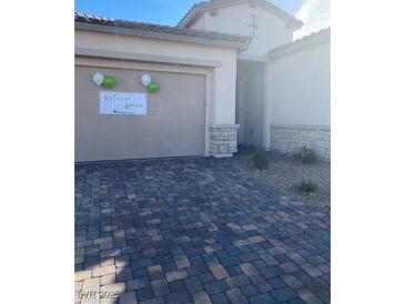 Charming home with a brick paved driveway and neutral colored garage, decorated with balloons and a welcome home banner at 740 Omaggio Pl, Henderson, NV 89011